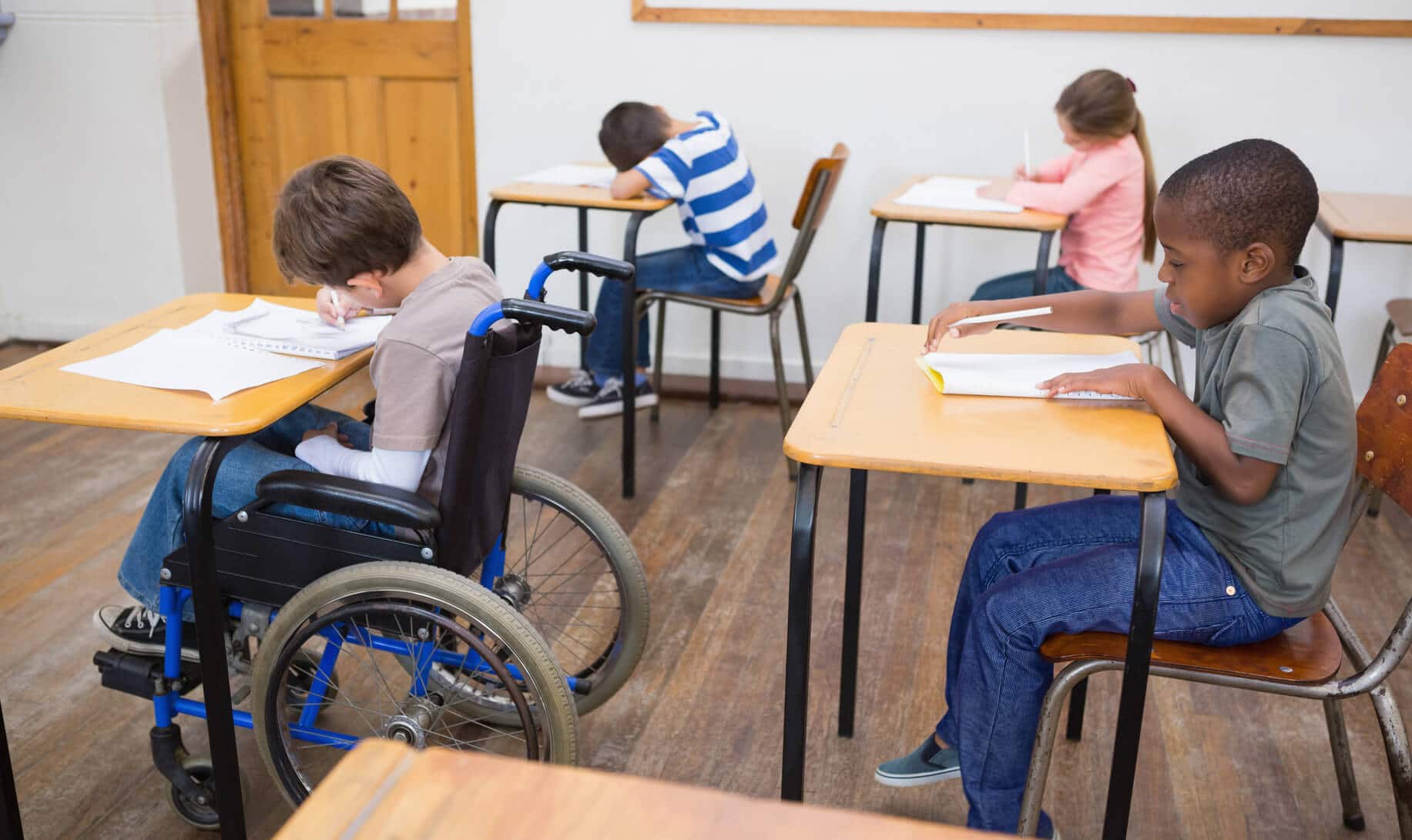 photodune-8709055-disabled-pupil-writing-at-desk-in-classroom-at-the-elementary-school-m